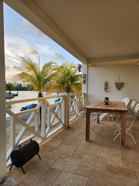 a balcony with a table and a view of the water at Your Cozy Vacation House in Kralendijk