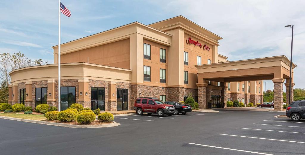 un hotel con bandera americana en un estacionamiento en Hampton Inn Oak Grove Fort Campbell, en Oak Grove