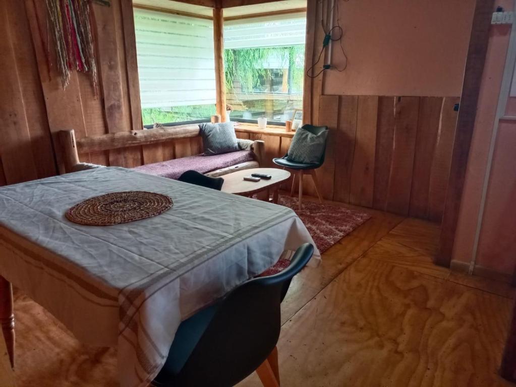 sala de estar con mesa y sofá en Cabañas Zarapito, en Quellón