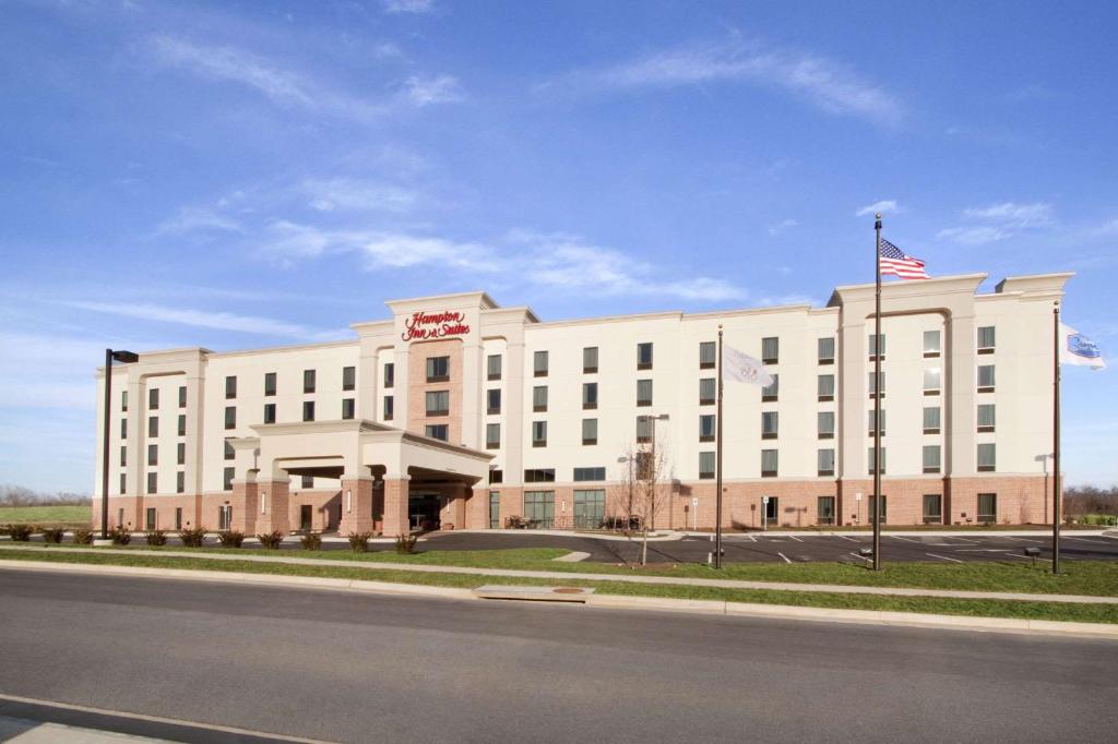 um grande edifício branco com uma bandeira americana em Hampton Inn & Suites Charles Town em Charles Town