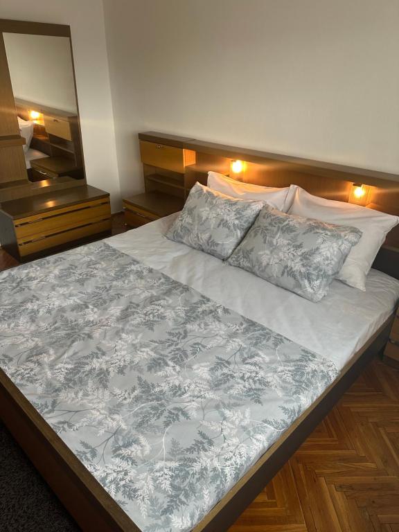 1 dormitorio con 1 cama grande con sábanas y almohadas blancas en Apartment Bella en Požega