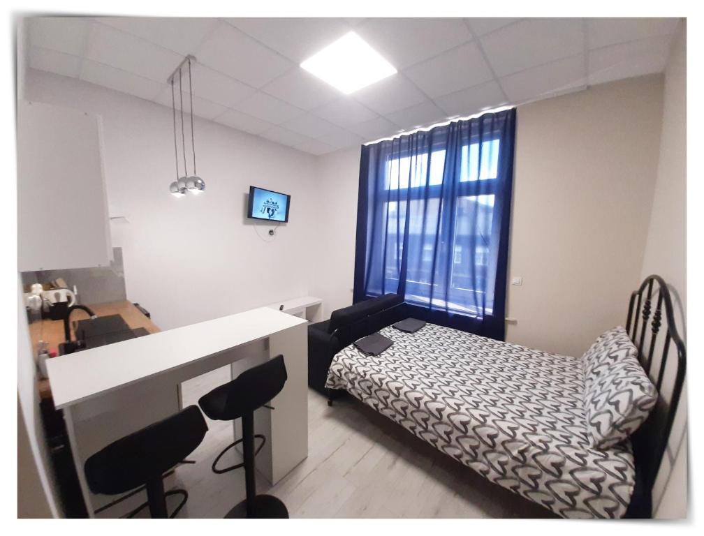 een kamer met een bed en een bureau met stoelen bij SouvenirAppart Sienkiewicza in Bydgoszcz