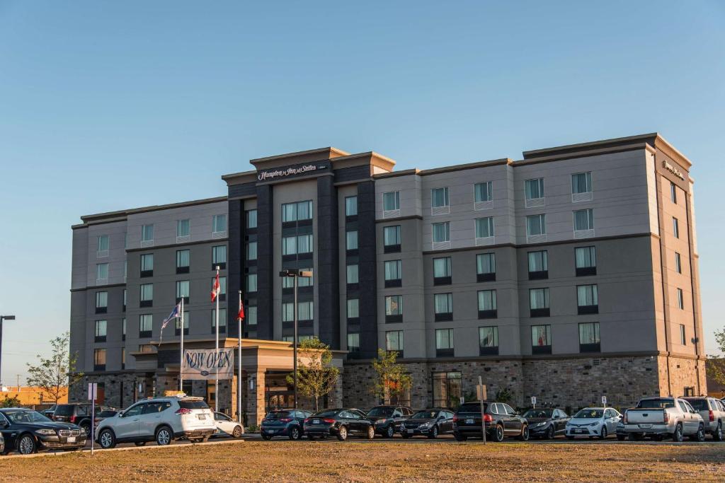a large building with cars parked in a parking lot at Hampton Inn & Suites by Hilton Bolton in Bolton