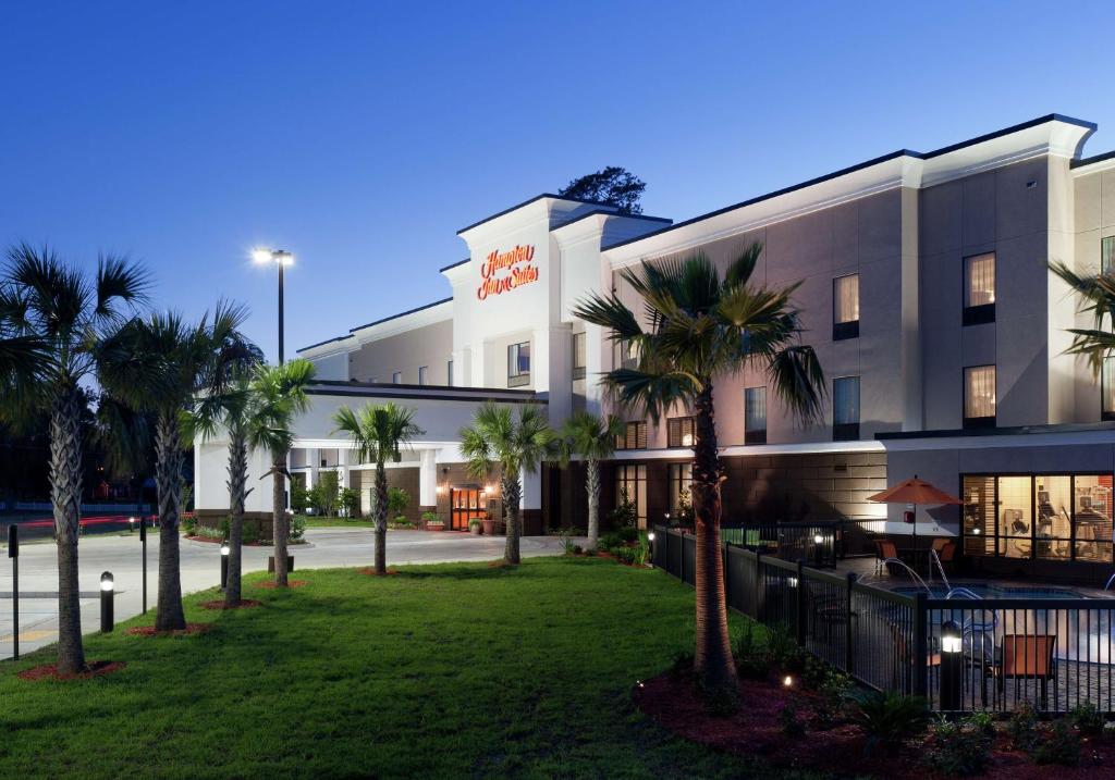 a hotel with palm trees in front of a building at Hampton Inn and Suites Marksville in Mansura
