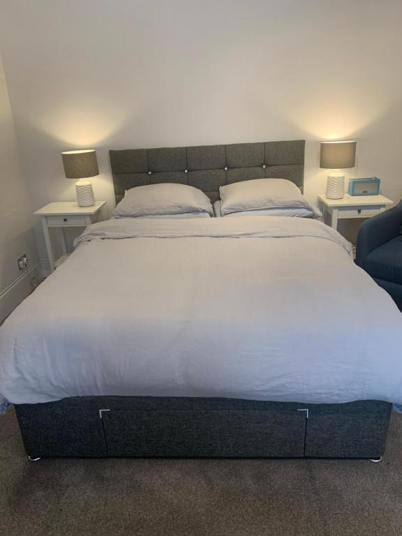 een groot bed in een kamer met 2 tafels en 2 lampen bij St Martins in Londen