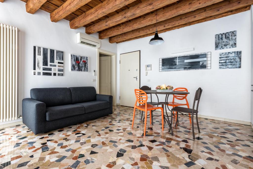 un soggiorno con divano nero e tavolo di Lovely apartment In Vicenza a Vicenza