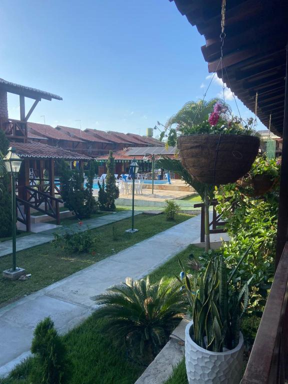 a garden with two baskets of plants and a sidewalk at Casa Paraíso in Gravatá