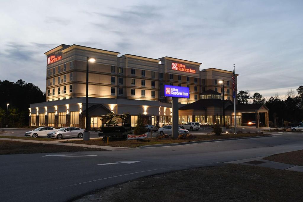 ein großes Gebäude mit Autos auf einem Parkplatz in der Unterkunft Hilton Garden Inn Jacksonville in Jacksonville