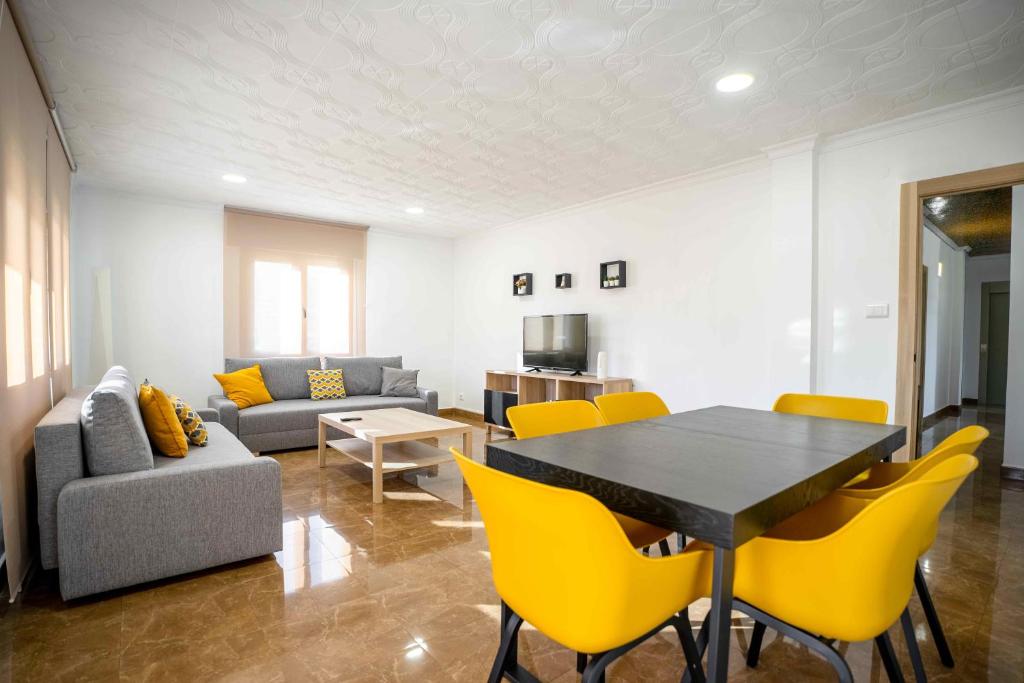 a living room with a table and yellow chairs at Casa Palau in Morella