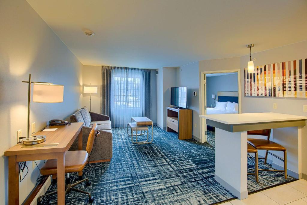 Habitación de hotel con escritorio y sala de estar. en Homewood Suites by Hilton South Bend Notre Dame Area, en South Bend