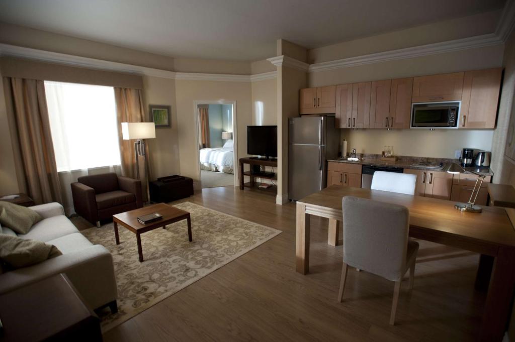 Homewood Suites By Hilton Montgomery EastChase في Mitylene: غرفة معيشة مع مطبخ وغرفة طعام