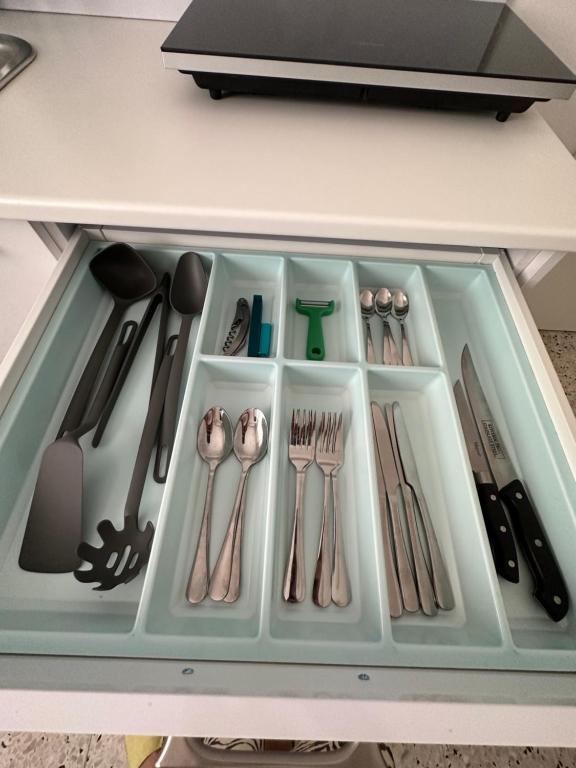 a drawer filled with utensils in a cabinet at Sea breeze in Bat Yam