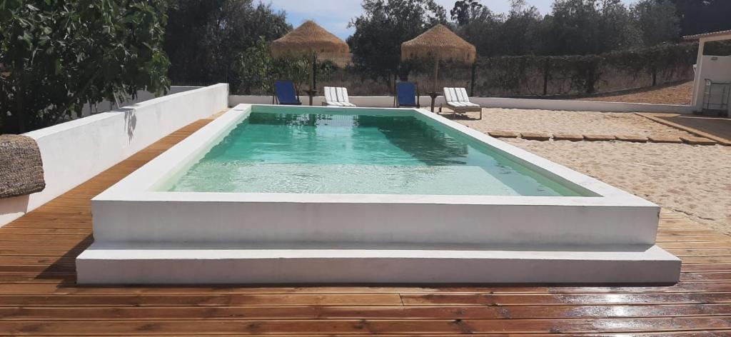 a large pool with chairs and a table at Monte da Venda de Baixo in Santa Margarida da Serra