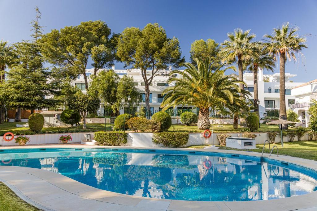 a swimming pool with trees and a building in the background at PENTHOUSE IN GOLDEN MILE in Marbella
