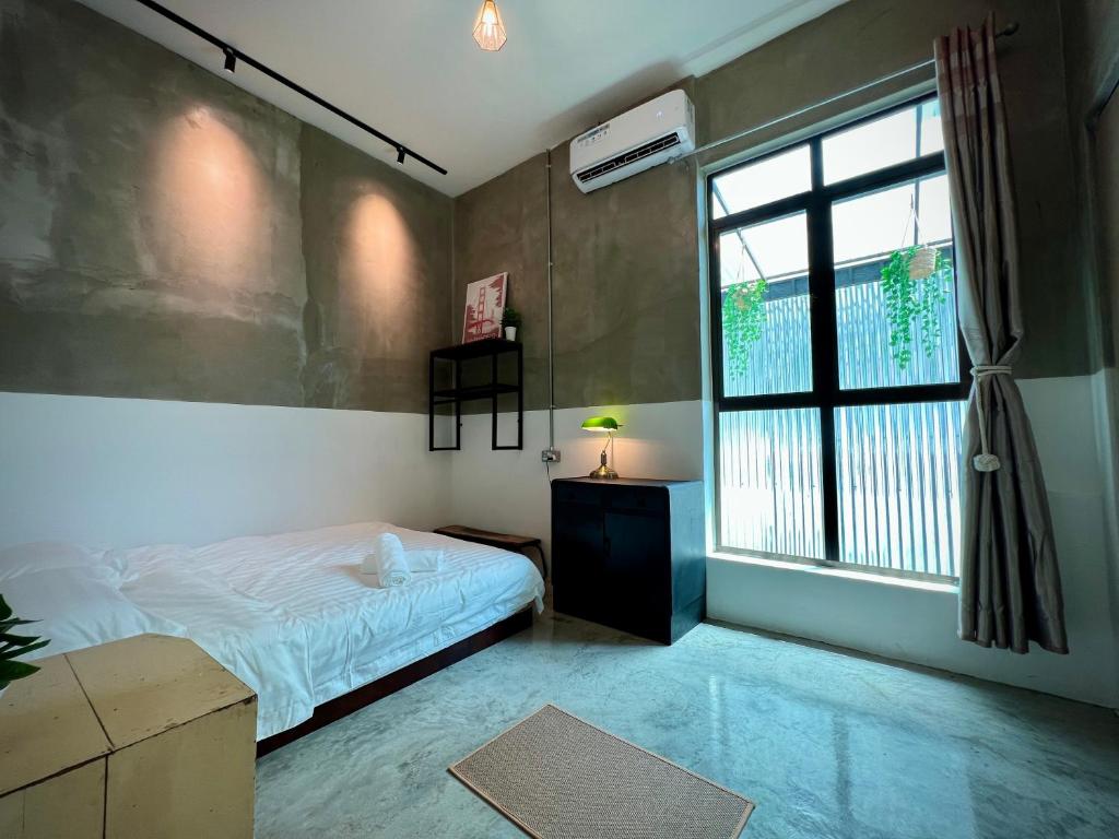 um quarto com uma cama e uma janela em DoSomething Guest House 5 em Ipoh