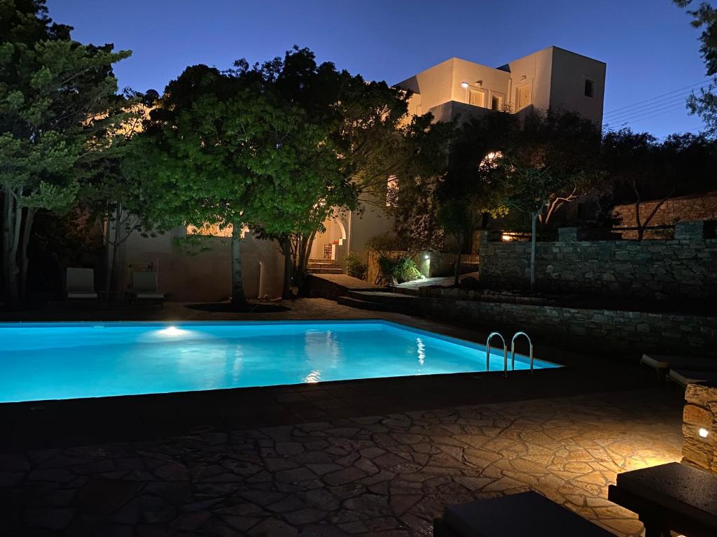 a swimming pool at night with a house in the background at Apaggio Apartments in Katapola