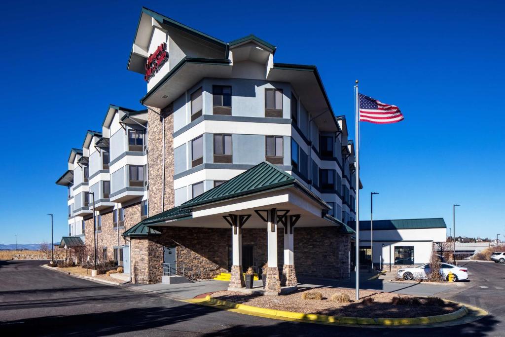a hotel with an american flag in front of it at Hampton Inn & Suites Parker in Parker