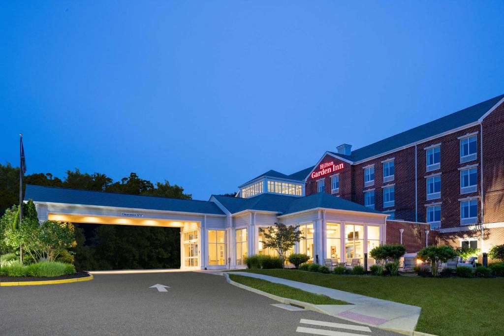 a hotel with a parking lot in front of a building at Hilton Garden Inn Mystic/Groton in Groton