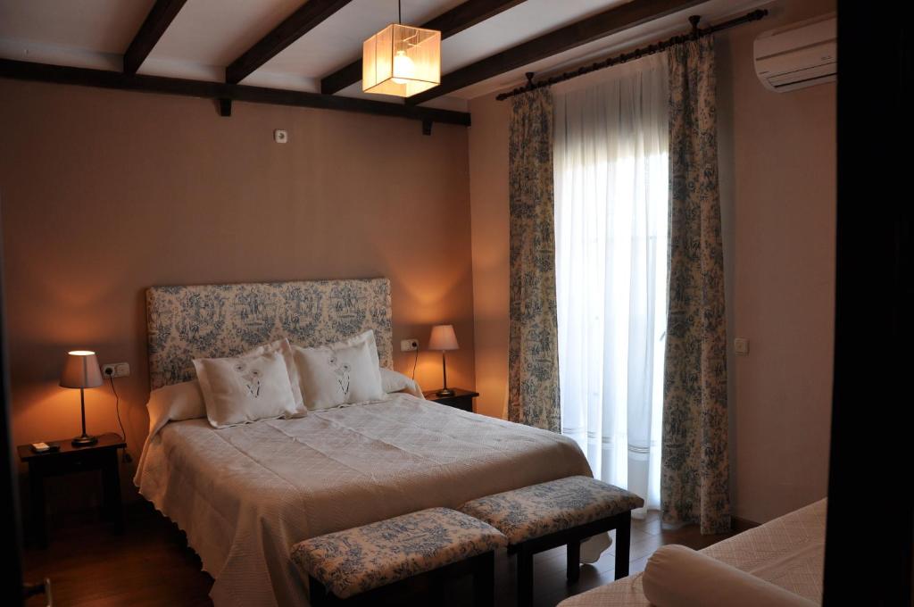 - une chambre avec un lit et une grande fenêtre dans l'établissement Apartamentos El Mirador Del Soto, à Sotoserrano
