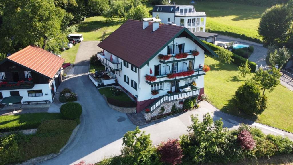 une grande maison blanche avec un toit marron dans l'établissement Pension Semler, à Mondsee