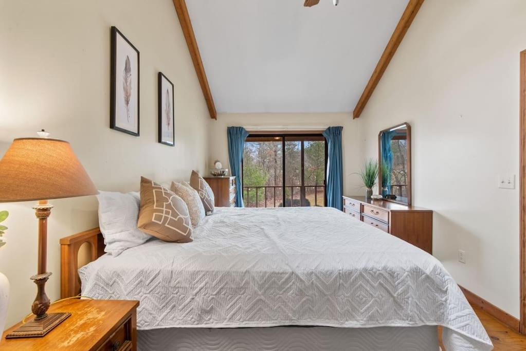 1 dormitorio con 1 cama y 1 mesa con lámpara en Luxury Cabin w/ Jacuzzi-Fireplace & Amazing View - Heidi, en Blairsville