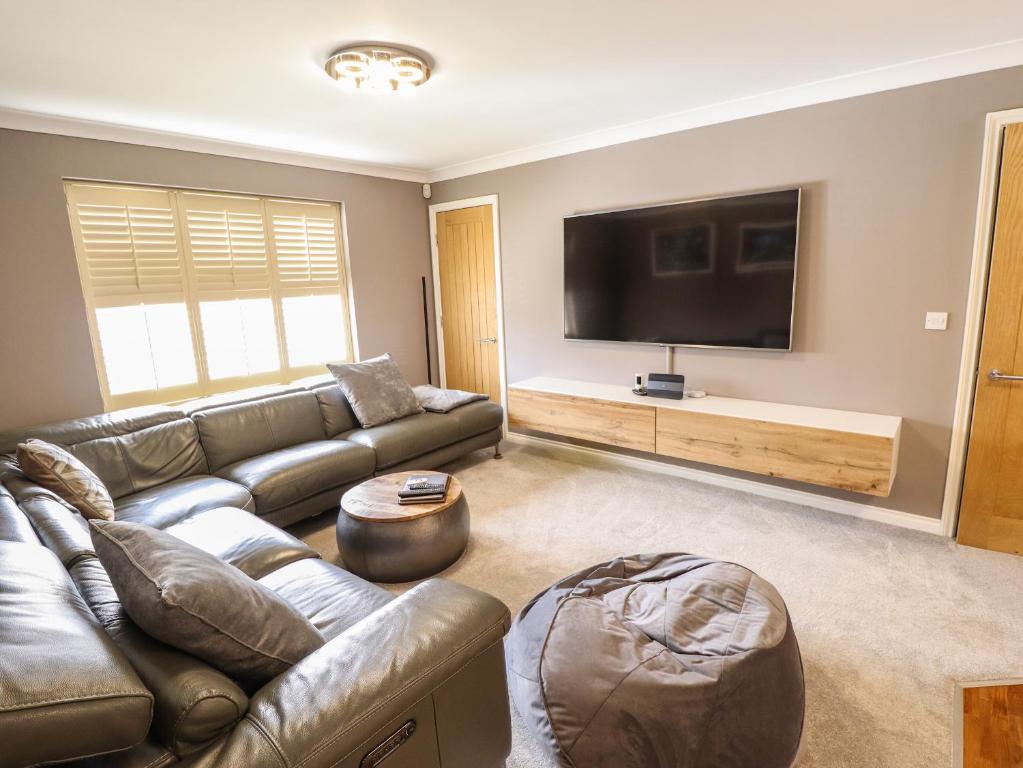 a living room with a couch and a flat screen tv at 10 Mellor Way in Grimsby