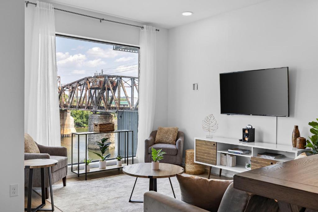 a living room with a tv and a large window at River View, Balcony, Germantown, Central, Elevator in Nashville