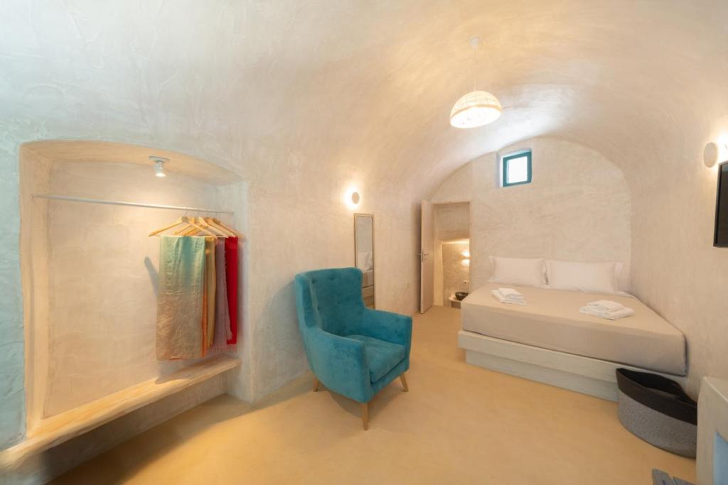 una camera con letto e sedia blu di Marla Luxury Residences a Megalochori