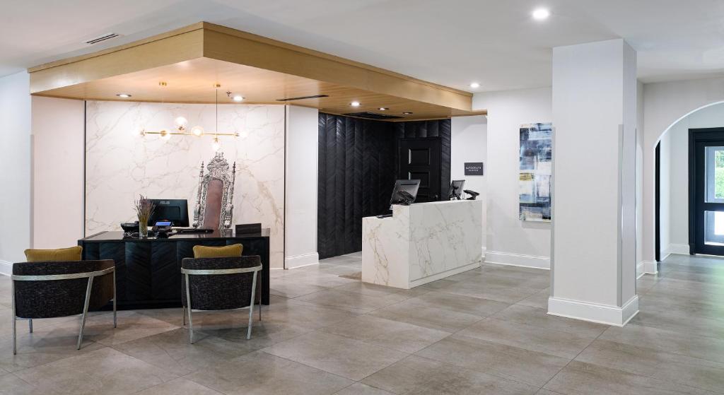 a lobby with a counter and chairs in a building at The Siena Hotel, Autograph Collection in Chapel Hill