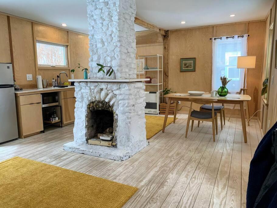 a living room with a stone fireplace in a kitchen at Modern Cottage Two (The Lorca, Catskills) in Shandaken