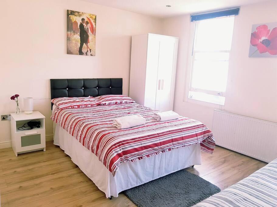 a bedroom with a large bed and a window at Cosy Studio Flat in Great Locationin London in London