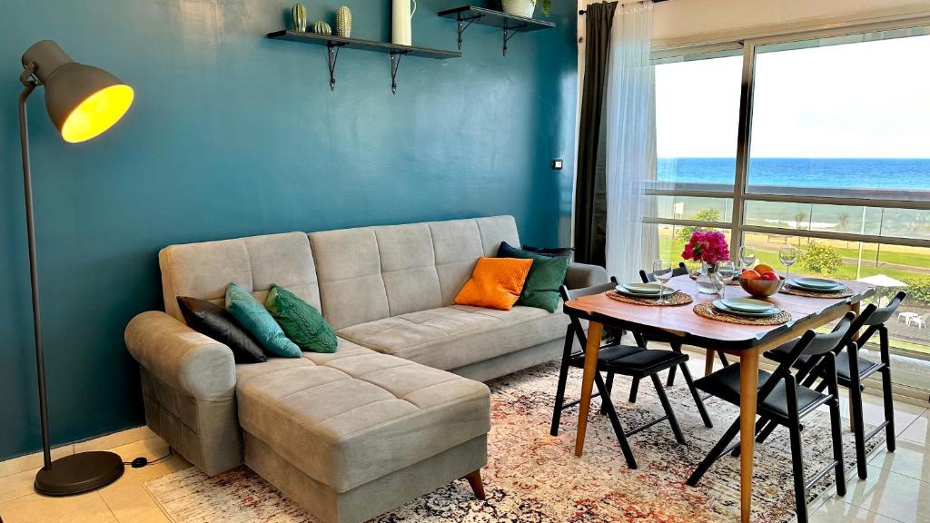 Gugel Waves Apartments GW208 في نهاريا: غرفة معيشة مع أريكة وطاولة