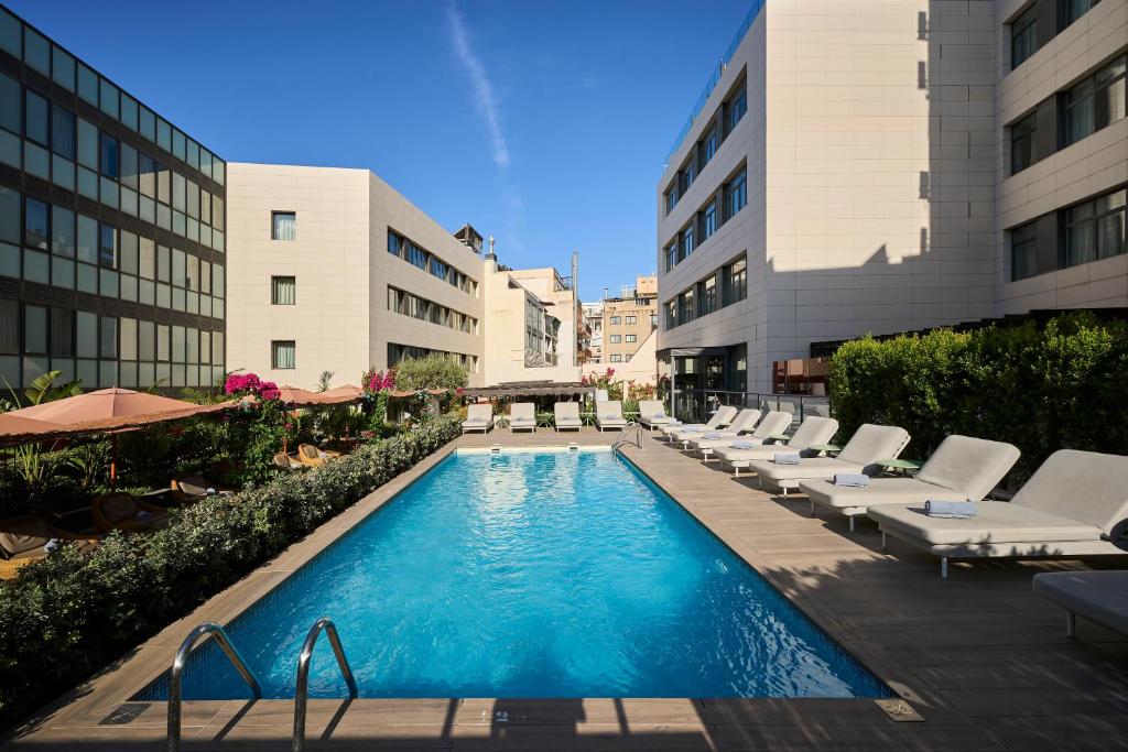巴塞隆納的住宿－加泰羅尼亞蘭布拉大道酒店，一座带躺椅的游泳池