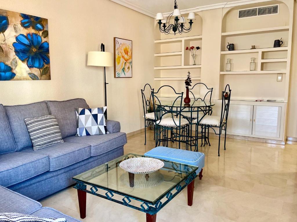 a living room with a blue couch and a table at Wallada Vistalegre in Córdoba