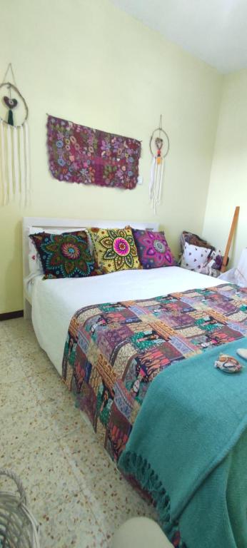 1 dormitorio con 1 cama con un edredón colorido en בית הלב en Nahariyya