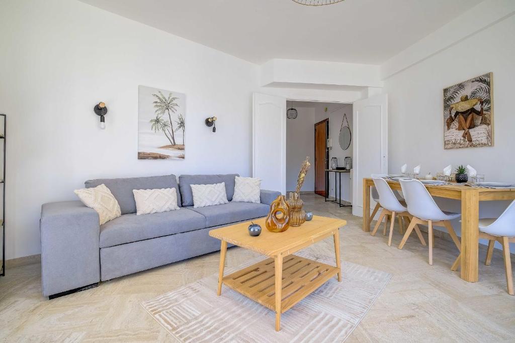 un salon avec un canapé bleu et une table dans l'établissement Sublime Two bedroom apartment with Terrace, à Cannes