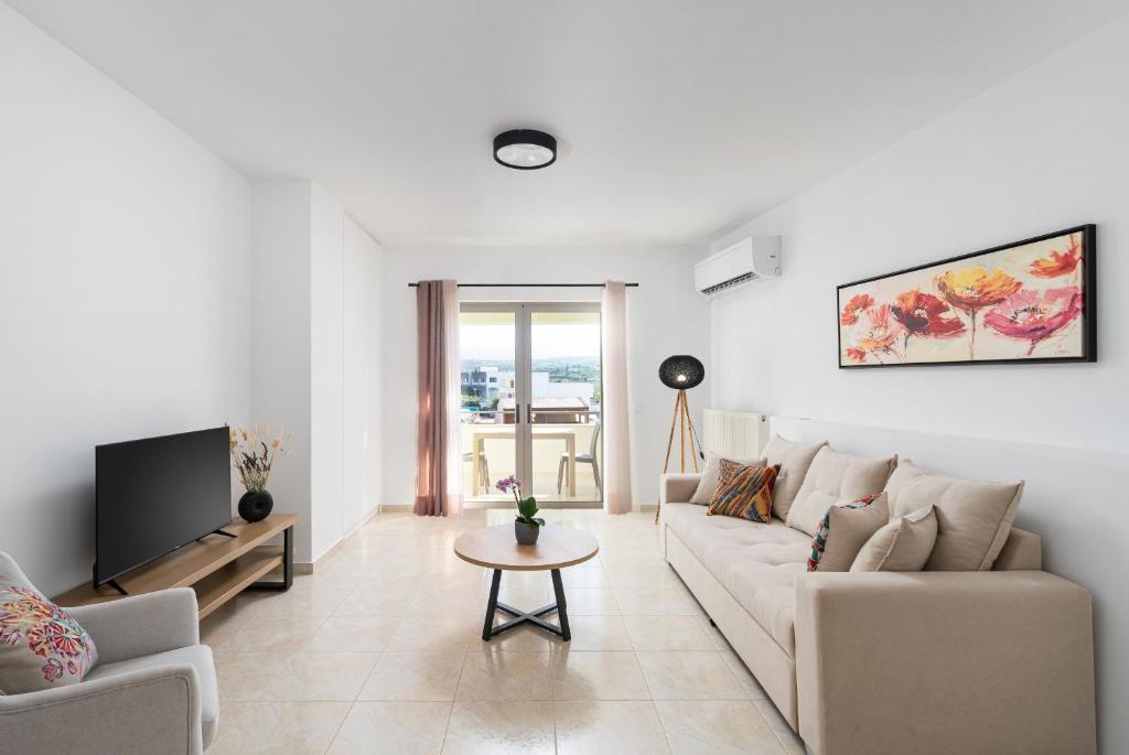 a living room with a couch and a tv at K&D Central Suite in Sitia