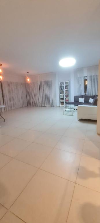 Bayit Weganにあるפנטהאוז בירושליםの白い床とソファが備わる広い客室です。