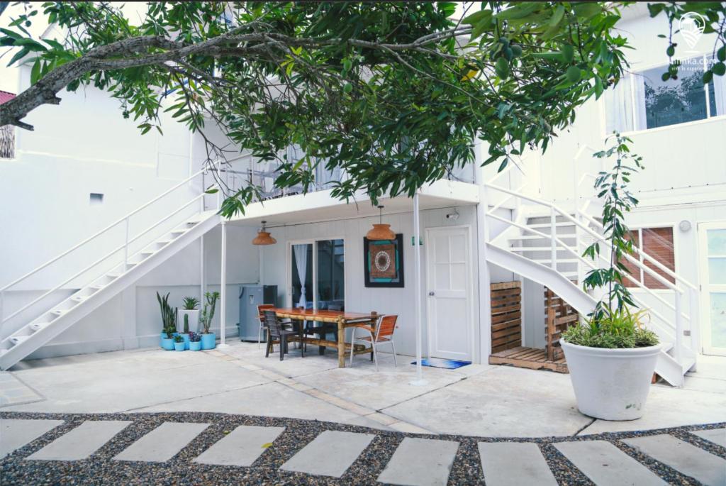 Casa blanca con escalera y mesa en Blue Sand House B&B, en Cartagena de Indias