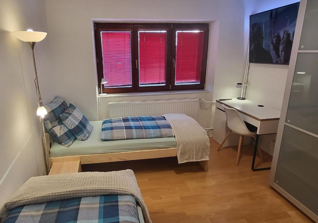 1 dormitorio con cama, escritorio y ventana en Apartmán Husovka Bruntál - pokoj POLLY en Bruntál
