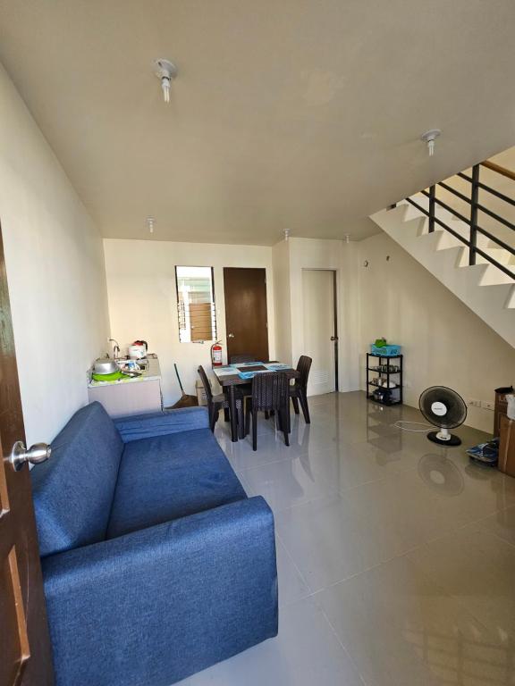 sala de estar con sofá azul y mesa en Casa Mira Coast Apartment with Motorbike, en Dumaguete