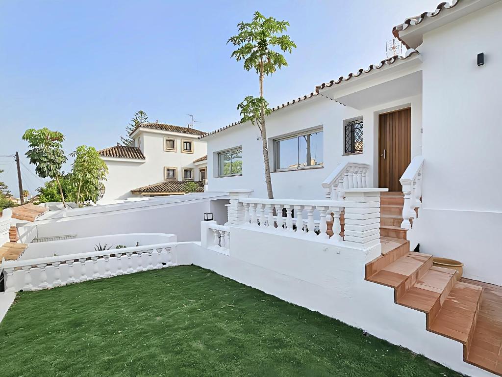 une maison blanche avec une pelouse verte dans l'établissement Luxury villa city Centre, à Marbella