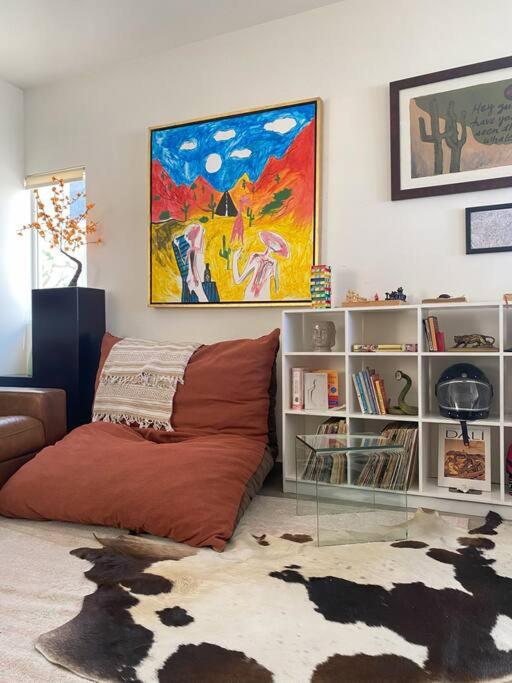 una sala de estar con sofá y una pintura en la pared en Natural creative space in downtown Cabo!, en Cabo San Lucas