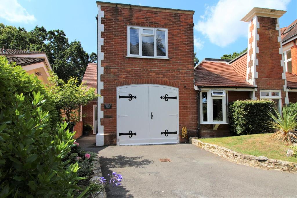 uma porta de garagem branca numa casa de tijolos em Middle Chine em Bournemouth
