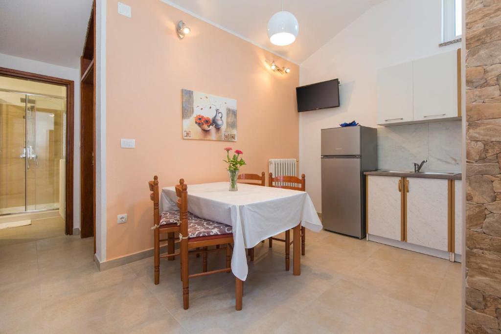 a kitchen and dining room with a table and chairs at Apartman Ana in Labin
