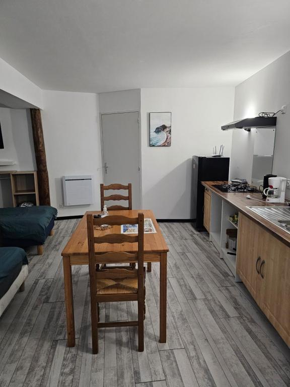 eine Küche mit einem Holztisch und einem Stuhl in einem Zimmer in der Unterkunft Studio in Fains-les-Sources