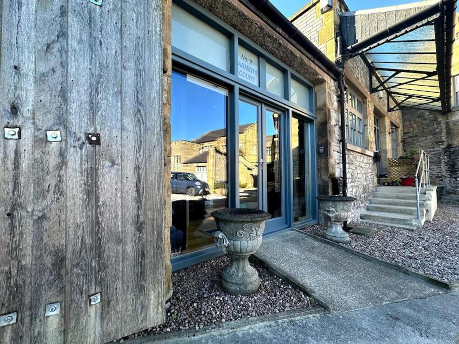 a building with two vases in front of a window at Cosy & quirky cottage in the heart of Bakewell. in Bakewell