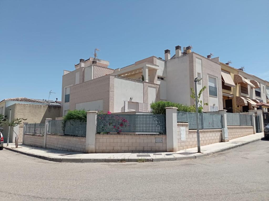 una casa con una valla delante de una calle en APARTAMENTOS TURISTICOS LAS CINCO JOYAS, en Linares