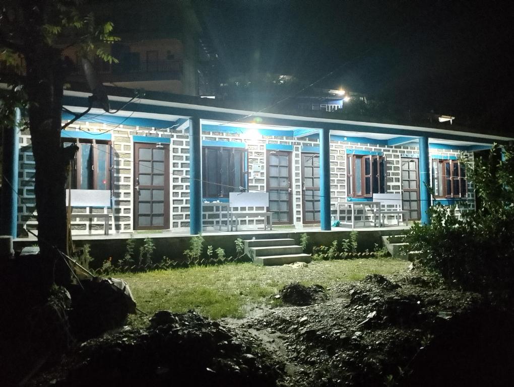 ein Gebäude mit blauem Licht in der Nacht in der Unterkunft Birthi Waterfall Homestay in Girgaon