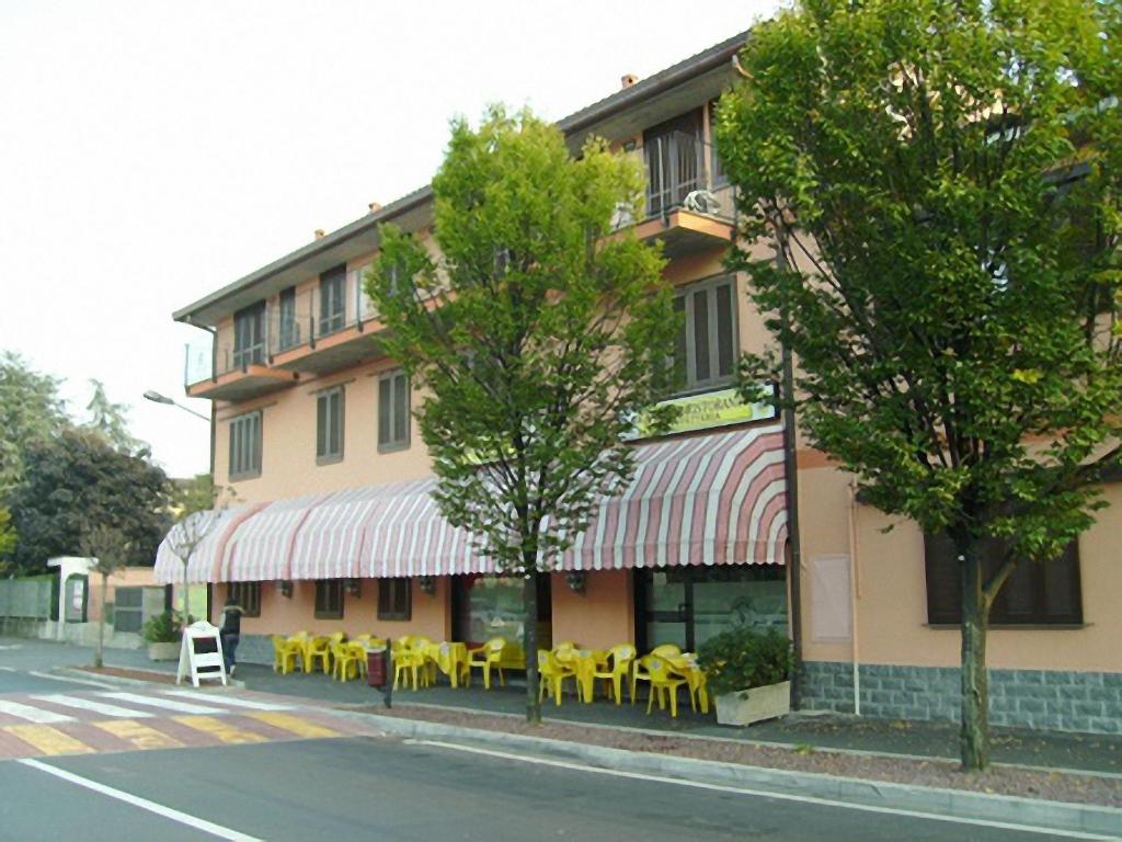 un bâtiment avec des tables et des chaises jaunes dans une rue dans l'établissement Il Piccolo Golf, à Muggiò